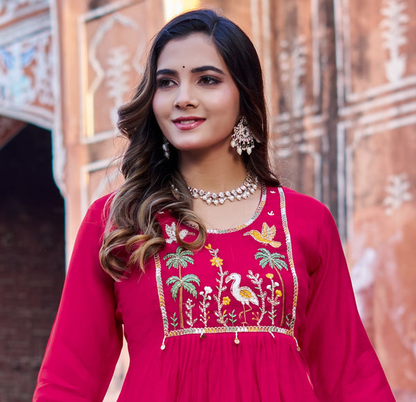 Woman wearing a red embroidered dress with a decorative background