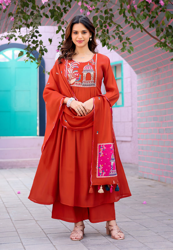 Woman in a traditional red outfit with embroidery standing in front of a decorative archway.