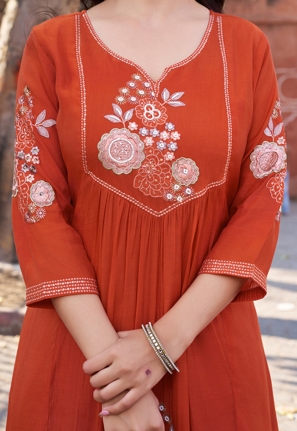 Red embroidered dress with floral patterns on a blurred background