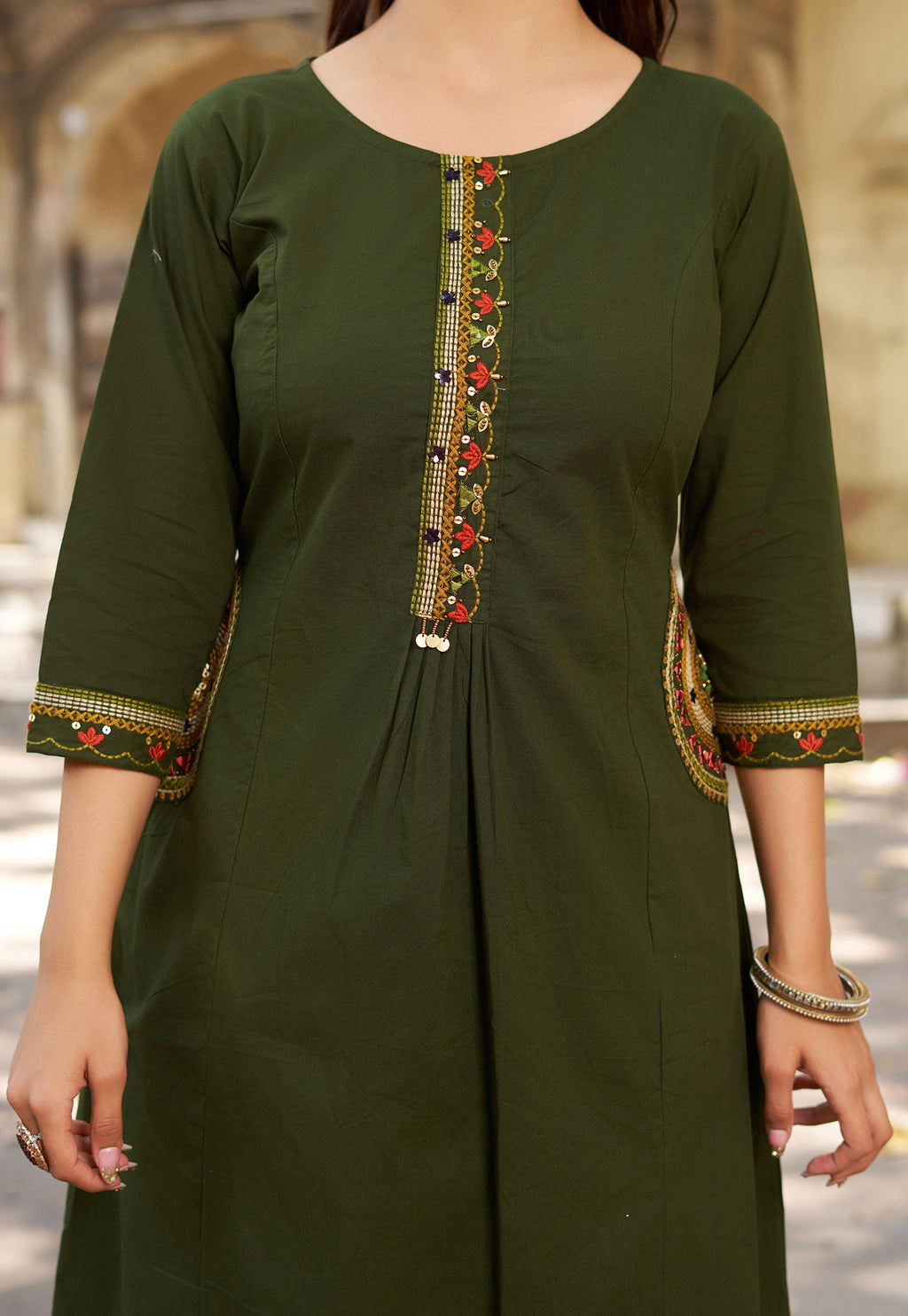 Green kurta with intricate embroidery on a blurred background
