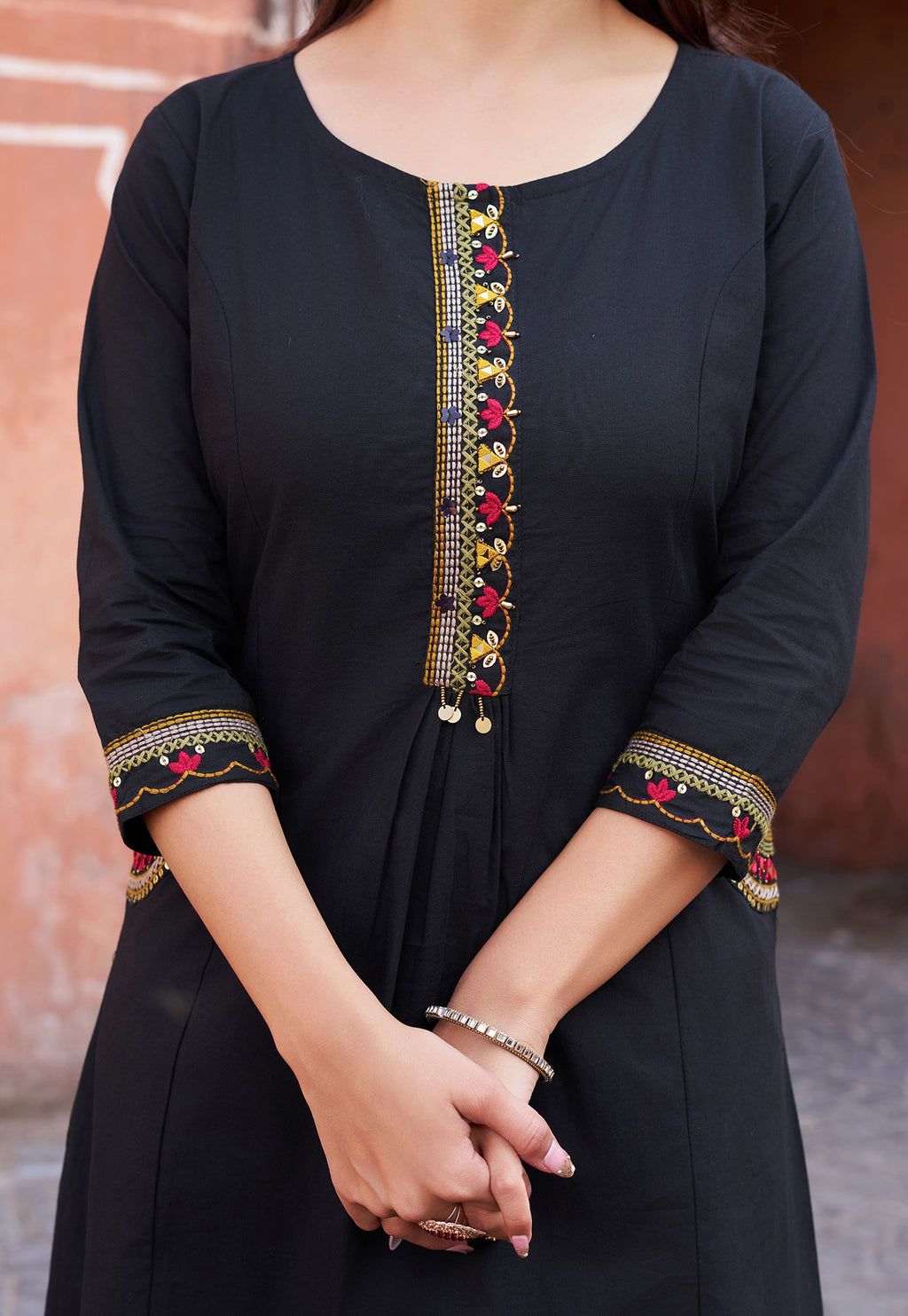 Black kurta with colorful embroidery on a blurred background