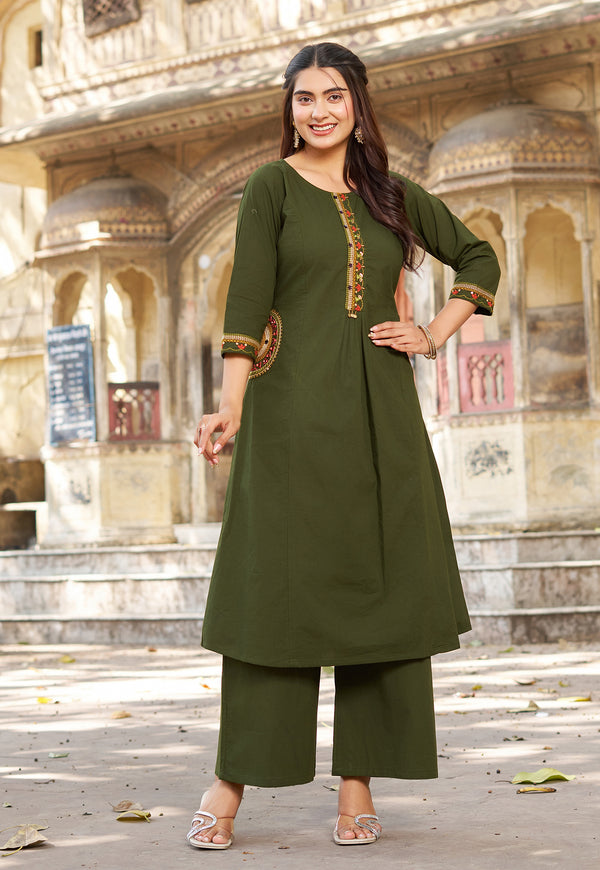 Woman in a green traditional outfit standing in front of an architectural background